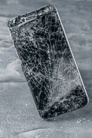 mobile phone with broken touchscreen on gray background.の写真素材