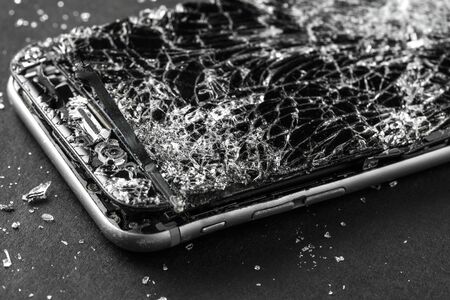 mobile phone with broken touchscreen on gray background.の写真素材