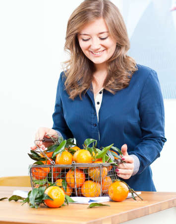 Woman hands with iron basket with fresh clementine copy space.の写真素材