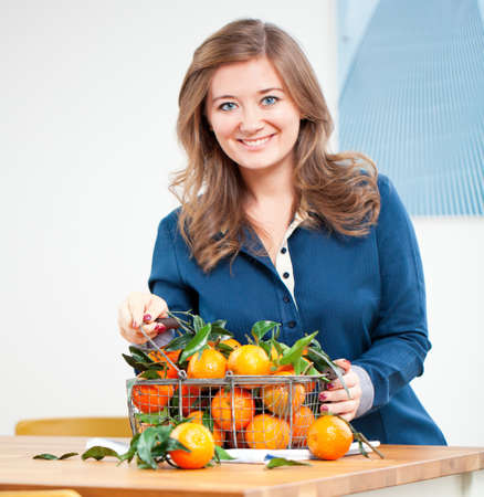 Woman hands with iron basket with fresh clementine copy space.の写真素材