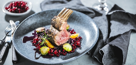 Roasted lamb or venison ribs on christmas table fetive dekoration food.の写真素材