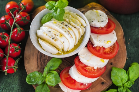 Caprese salad. Mozzarella cheese, tomatoes and basil herb leavesの写真素材