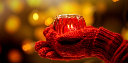 women holding christmas candel in warm glovesの写真素材
