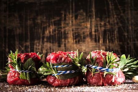 Fresh fillet steak on wooden table ready to grillの写真素材