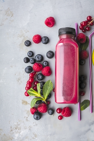 Healthy smoothies with fresh ingredients on a kitchen board.の写真素材