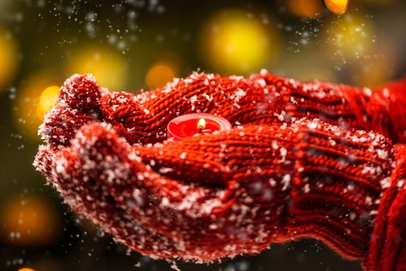women holding christmas candel in warm glovesの写真素材