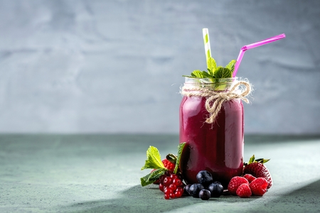 Healthy smoothies with fresh ingredients on a kitchen board.の写真素材
