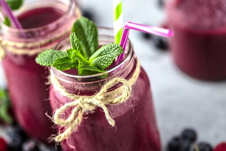 Healthy smoothies with fresh ingredients on a kitchen board.の写真素材