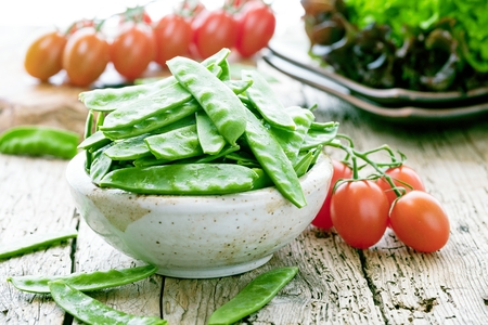 The pods of green beans on a wooden surface.の写真素材