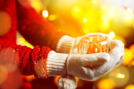women holding christmas candel in warm glovesの写真素材