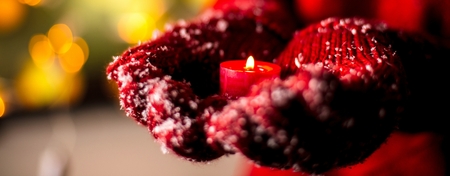 women holding christmas candel in warm glovesの写真素材