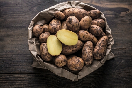 Fresh Bio Potatoes on wooden background closeup.の写真素材