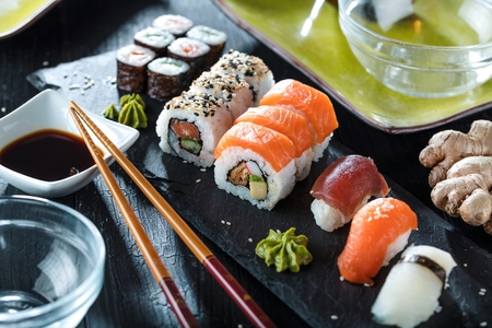 Sushi Set sashimi and sushi rolls served on stone slateの写真素材