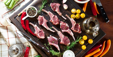Rack of lamb , raw meat with bone on rustic kitchen table at wooden background