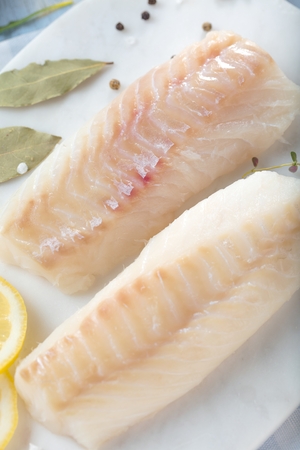 Fresh fish, raw cod fillets with addition of herbs and lemon