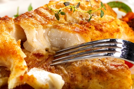 Fresh backed codfish filet on white tableの写真素材