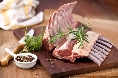 Rack of lamb , raw meat with bone on rustic kitchen table at wooden background, side view.の写真素材