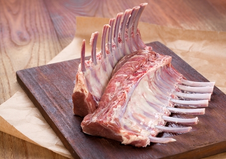 Rack of lamb , raw meat with bone on rustic kitchen table at wooden background, side view.の写真素材