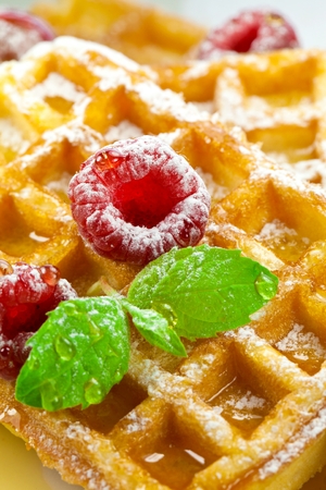 Traditional waffle Belgian with fresh raspberries on a saucer isolated on white background two sweet delicate and airy delicious breakfastの写真素材