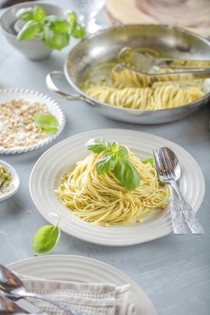 Pasta spaghetti with basil cream and cheese. Top view on grey stone table. Vegetarian vegetable pasta.の写真素材
