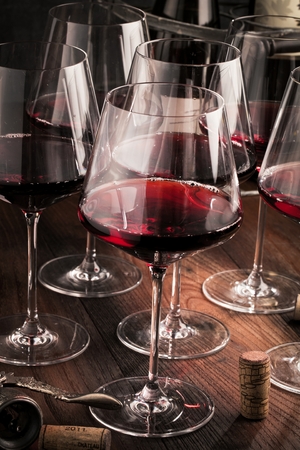 Red wine glass on dark wooden Tableの写真素材
