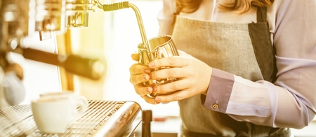 Women Barista using coffee machine for making coffee in the cafe.の写真素材