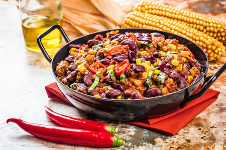Chili con carne in a clay bowl on a concrete or stone rustic background- traditional dish of mexican cuisine.Top viewの写真素材