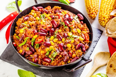 Chili con carne in a clay bowl on a concrete or stone rustic background- traditional dish of mexican cuisine.Top viewの写真素材