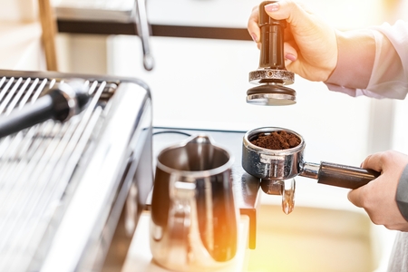 Women Barista using coffee machine for making coffee in the cafeの写真素材