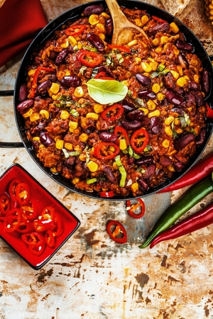 Chili con carne in a clay bowl on a concrete or stone rustic background- traditional dish of mexican cuisine.Top viewの写真素材