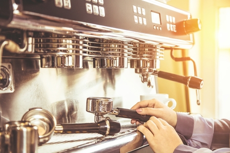 Women Barista using coffee machine for making coffee in the cafeの写真素材
