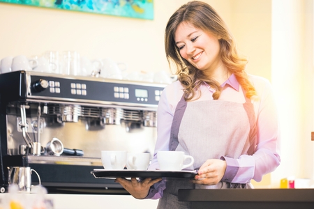 Women Barista using coffee machine for making coffee in the cafe.の写真素材