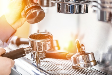 Barista using coffee machine for making coffee in the cafeの写真素材