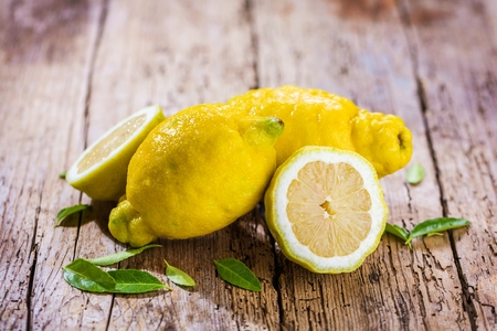 Fresh organic fruit - lemons on wood background selective focusの写真素材