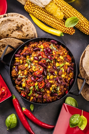 Chili con carne in a clay bowl on a concrete or stone rustic background- traditional dish of mexican cuisine.Top viewの写真素材