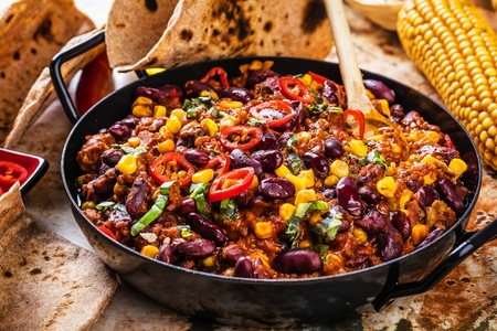 Chili con carne in a clay bowl on a concrete or stone rustic background- traditional dish of mexican cuisine.Top viewの写真素材