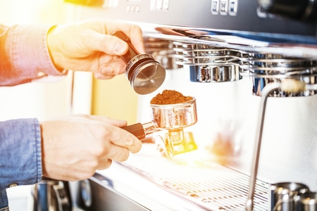 Barista using coffee machine for making coffee in the cafeの写真素材