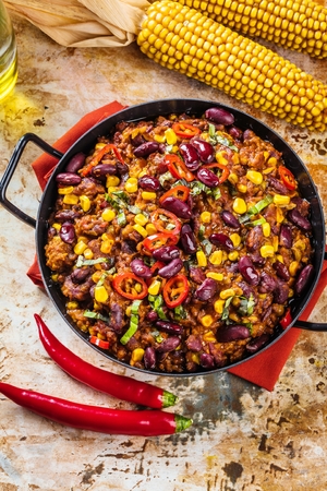 Chili con carne in a clay bowl on a concrete or stone rustic background- traditional dish of mexican cuisine.Top viewの写真素材