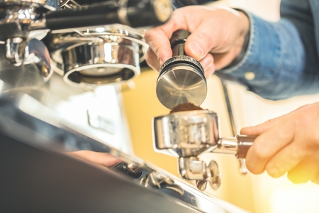 Barista using coffee machine for making coffee in the cafe.の写真素材