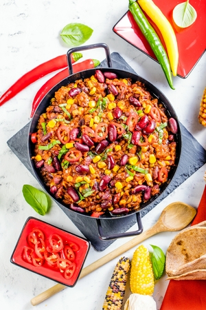 Chili con carne in a clay bowl on a concrete or stone rustic background- traditional dish of mexican cuisine.Top viewの写真素材