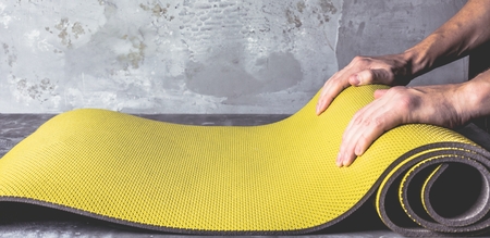 Cropped image of men hands rolling  yoga matの写真素材