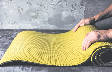 Cropped image of men hands rolling  yoga mat