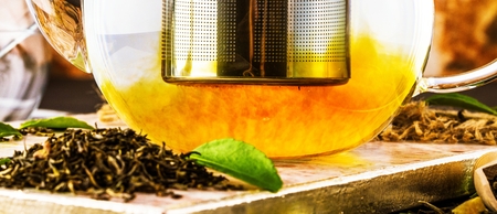 Teapot of freshly brewed black tea,warm soft light, darker background..の写真素材
