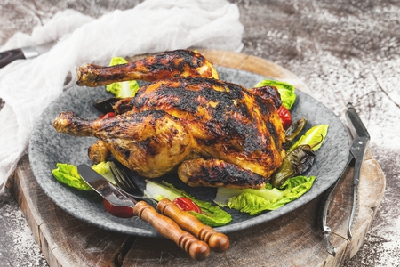 Chicken on wooden cutting board with sea salt and different spices over old metal surfaceの写真素材