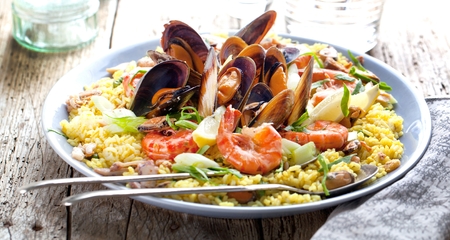 Paella with seafood. Traditional spanish food closeup on wooden tableの写真素材