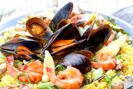 Paella with seafood. Traditional spanish food closeup on wooden tableの写真素材