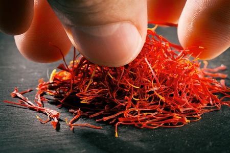 Heap of saffron threads on dark iron cast backgroundの写真素材