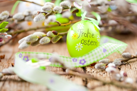 Easter Pussy-willow and  Easter egg on  wooden background. Happy Easter card. with Happy Easter text in german.の写真素材