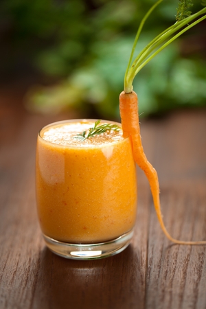 Carrot juice in glass and fresh carrots Healthy food on a grey stone background.の写真素材