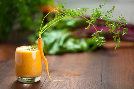 Carrot juice in glass and fresh carrots Healthy food on a grey stone background.の写真素材